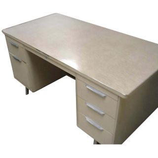 the desk is beige and has a white formica top the desk features four