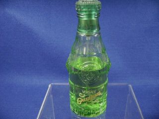 The green cap is still on the bottle. The bottle measures approx. 3 7