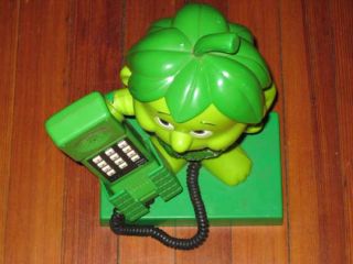  Green Sprout holds a telephone handset, all in luscious shades of