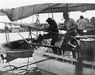 1937 photo Hoisting the yawl aboard the skipjack Esther W, Chesapeake