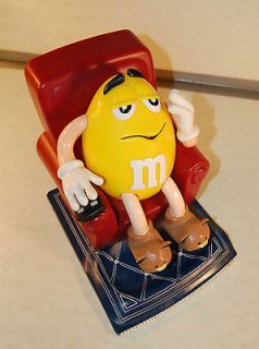 1999 YELLOW M&M CANDY DISPENSER SITTING IN LAZYBOY CHAIR w/ TV REMOTE